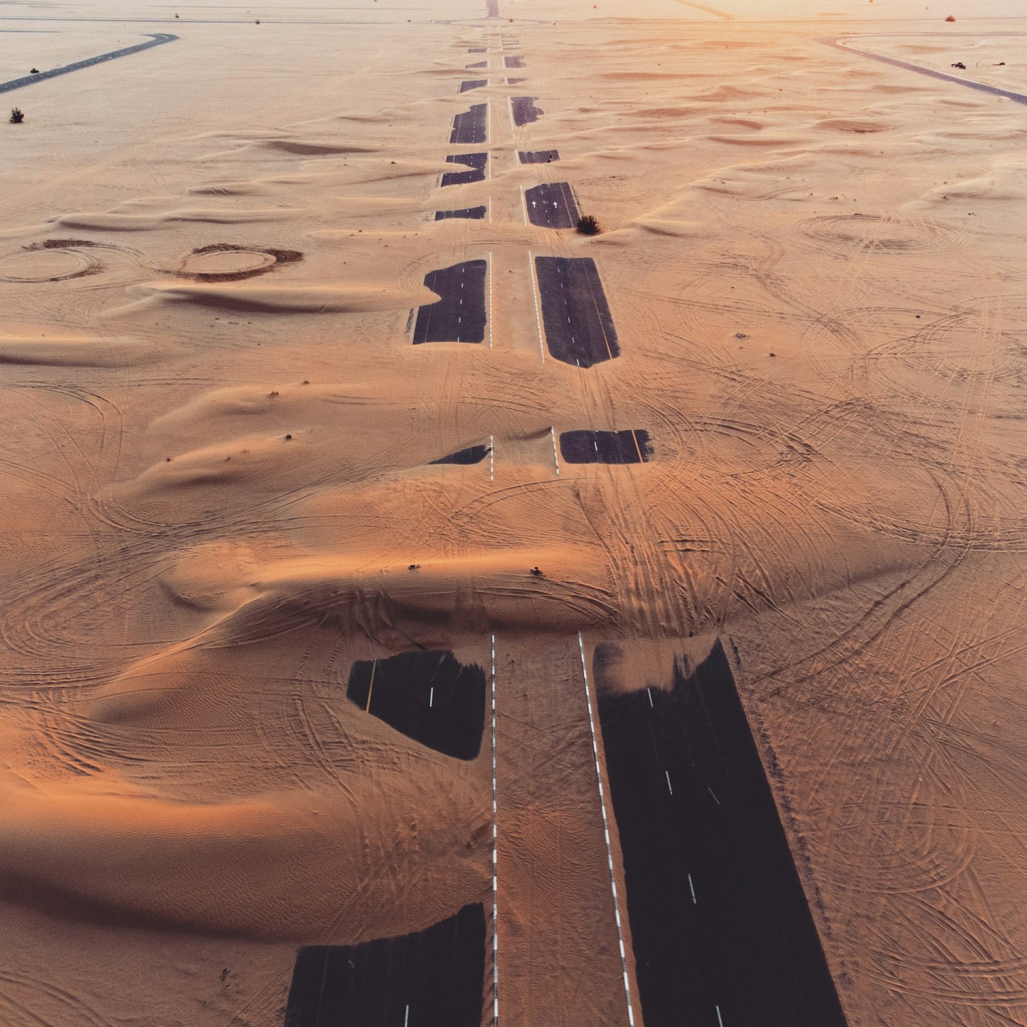 Aerial view of a road crossing a sandy desert landscape