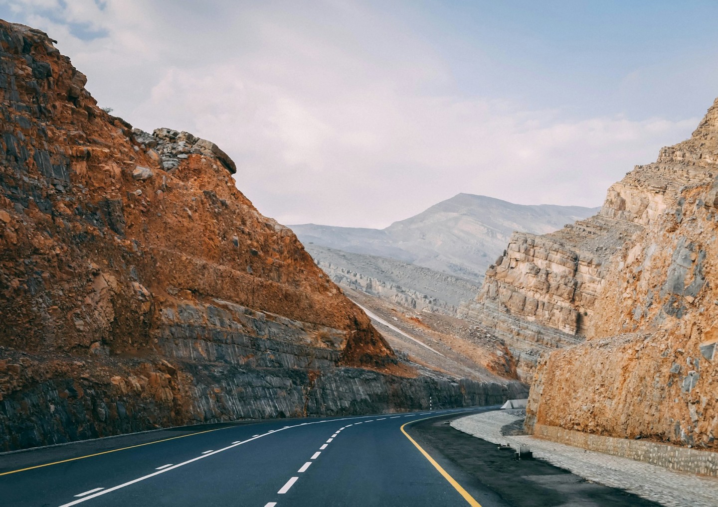 Paved road winding between the rocky mountains of Jebel Jais